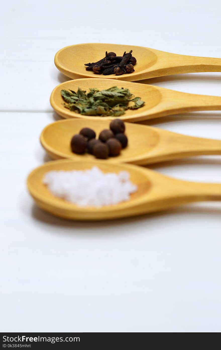 Four Assorted Spices on Brown Wooden Spoon