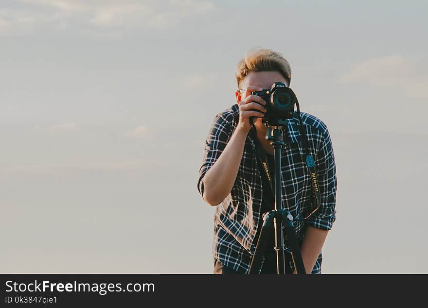 Man Holding Dslr Camera With Tripod