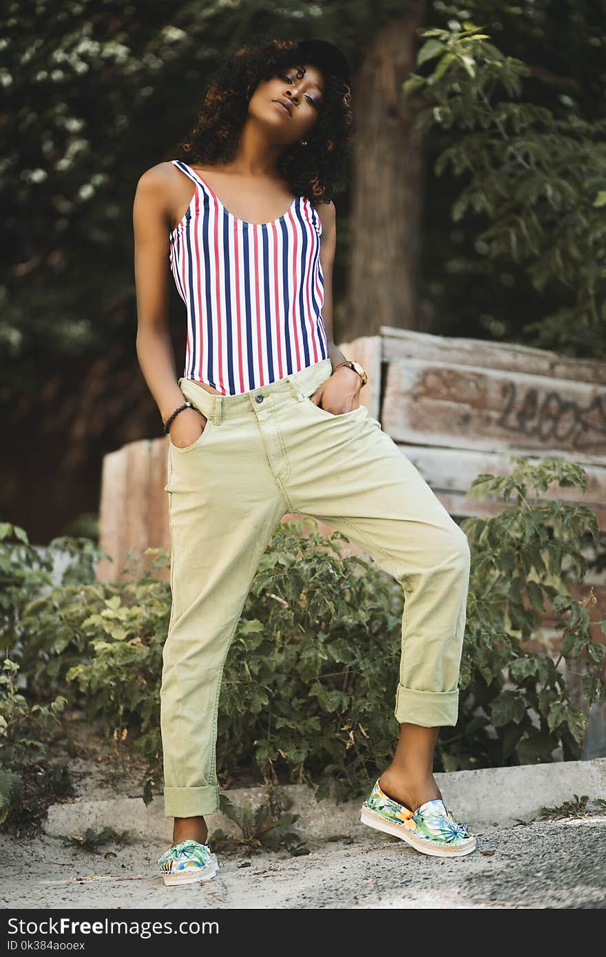 Woman in White and Black Stripe Spaghetti Strap Top and Beige Pants