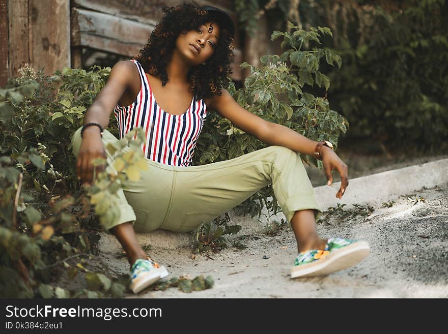 Photo of a Woman Sitting on Pavement