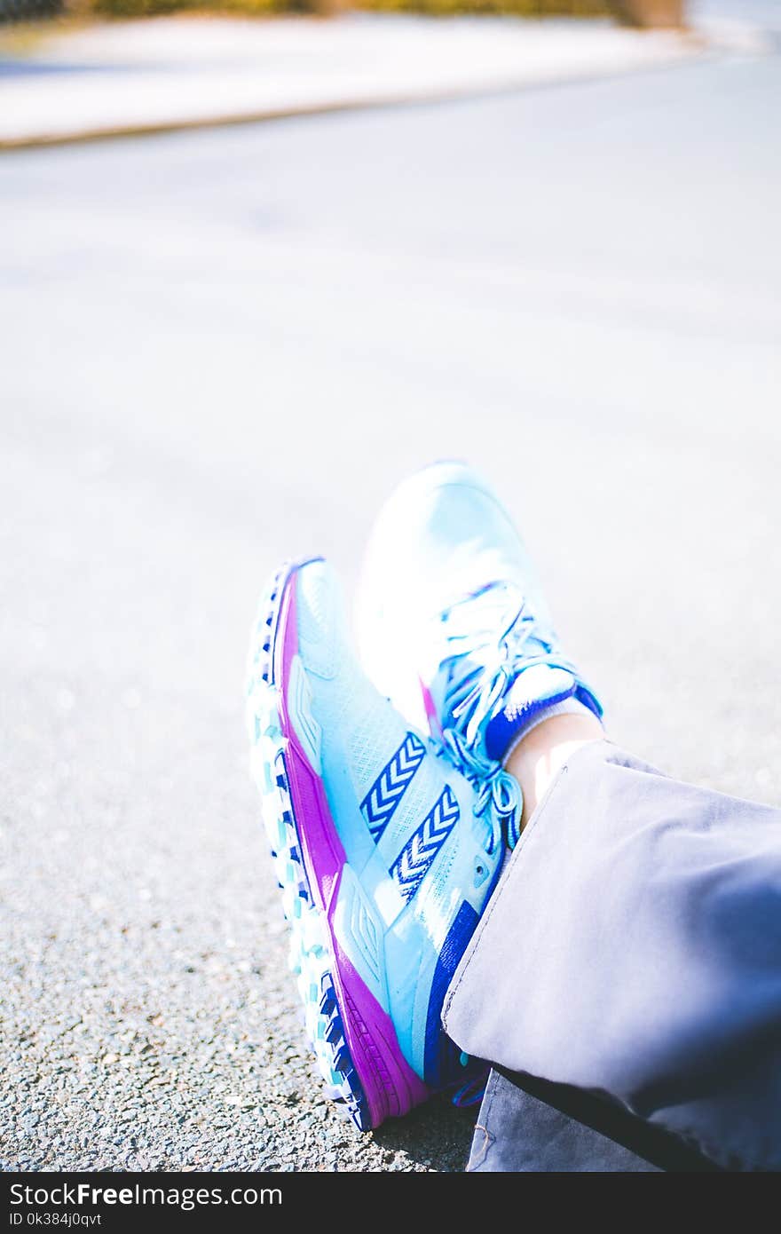 Person Wearing Pair of Blue-and-pink Running Shoes