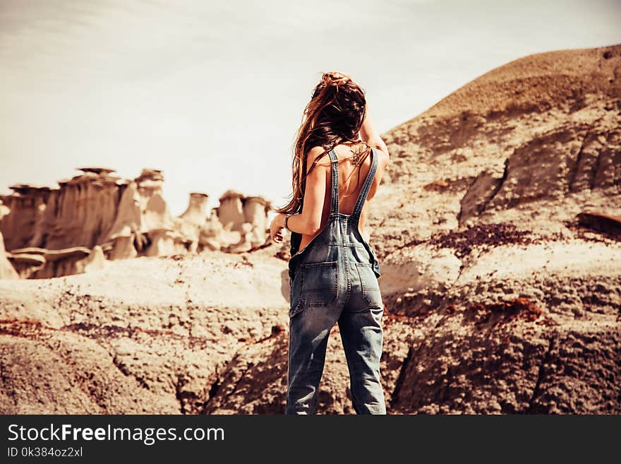 Woman Wearing Blue-washed Overalls Near Rock Formation