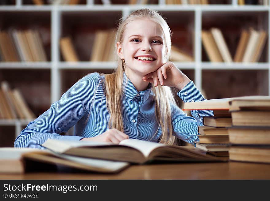 Teenage girl reading a book in library. Teenage girl reading a book in library