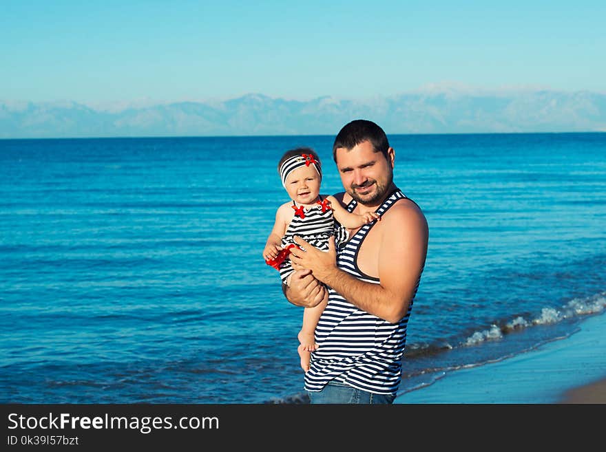 Happy father playing with cute little daughter at the beach