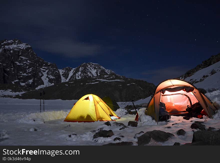 Magnificent view of the snow-capped mountains in a moonlit night. Night view of Mount Munku-Sardyk. Munku-Sardyk in the light of the moon. Tent and Camping hill landscape of at night.