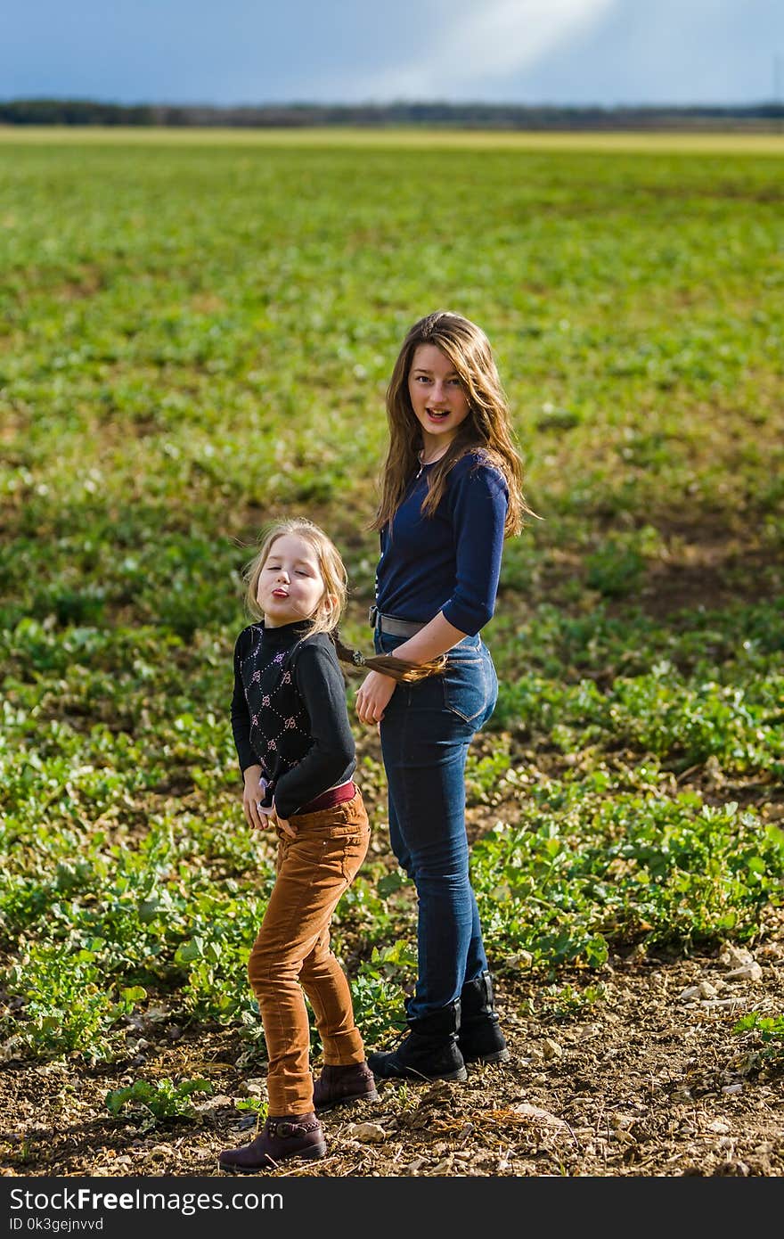 Two sisters happy with the nature, springtime in the field, France