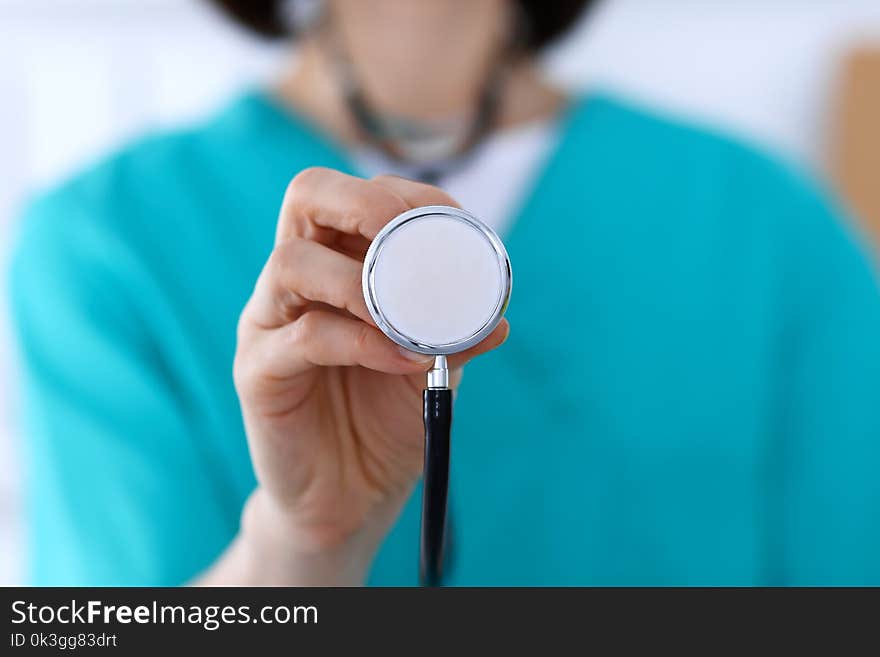 Female doctor holds stethoscope head closeup. Physicians ready to examine and help patient. Medical help and insurance in health care, best treatment and medicine concept.