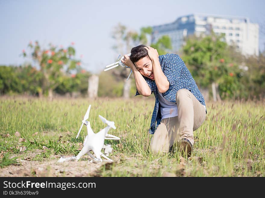 Man feel bad with crashed drone in the park. Man feel bad with crashed drone in the park