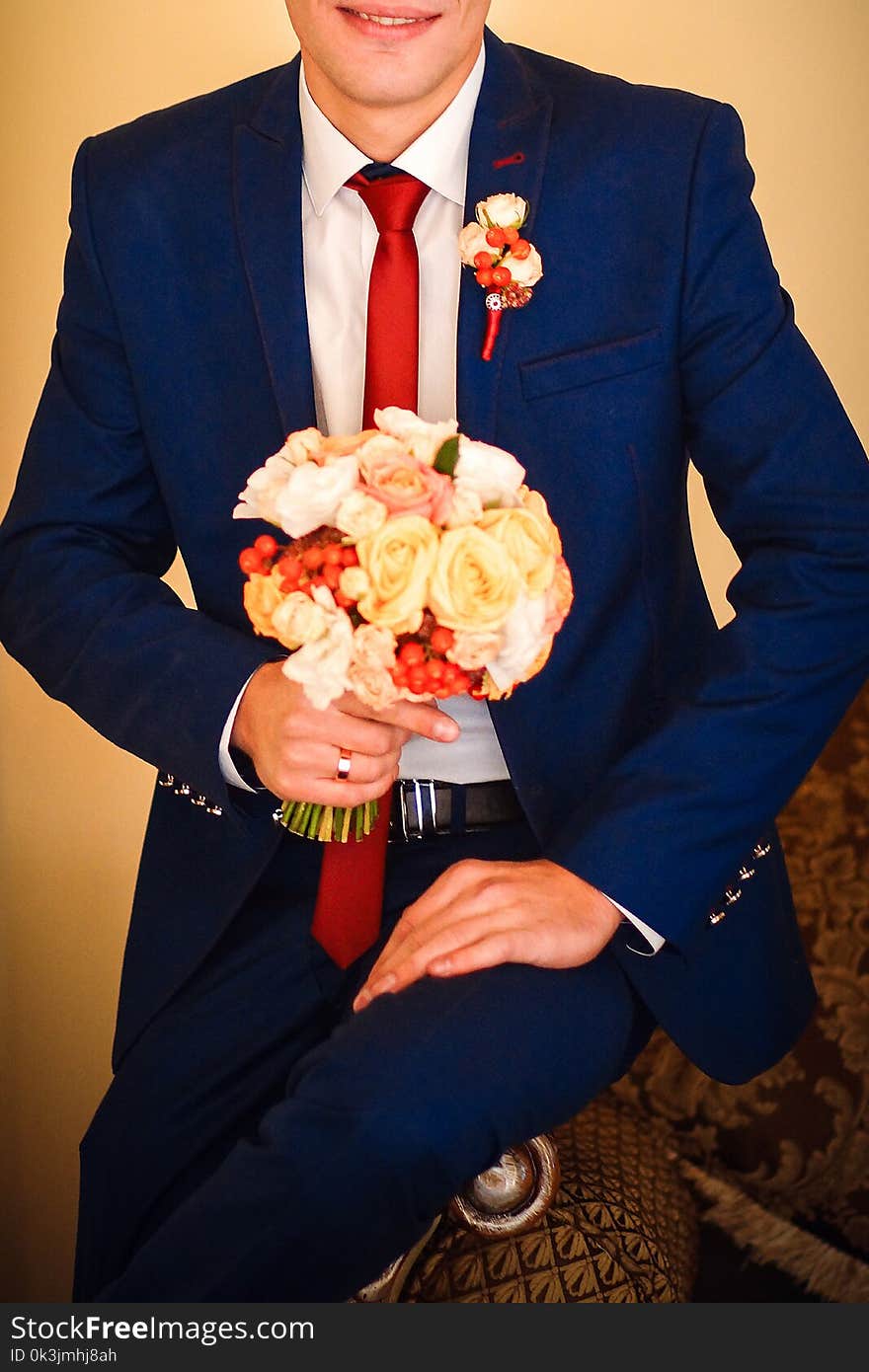 Groom holding a beautiful bouquet of tender and colorful flowers tied with a pretty ribbon. Groom holding a beautiful bouquet of tender and colorful flowers tied with a pretty ribbon