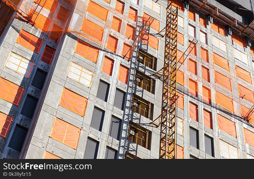 Construction crane column and concrete house under construction. Block of flats development