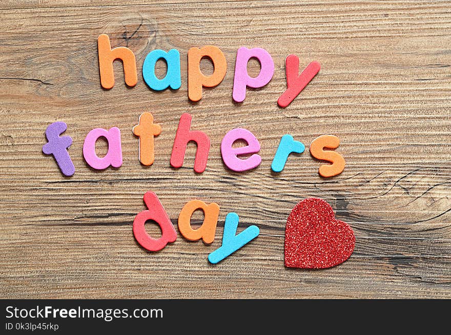 Happy fathers day on a wooden background with a red heart. Happy fathers day on a wooden background with a red heart