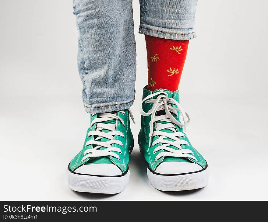 Stylish, bright, green sneakers and funny, happy socks on a white background. Sport, style, beauty, good mood. Stylish, bright, green sneakers and funny, happy socks on a white background. Sport, style, beauty, good mood