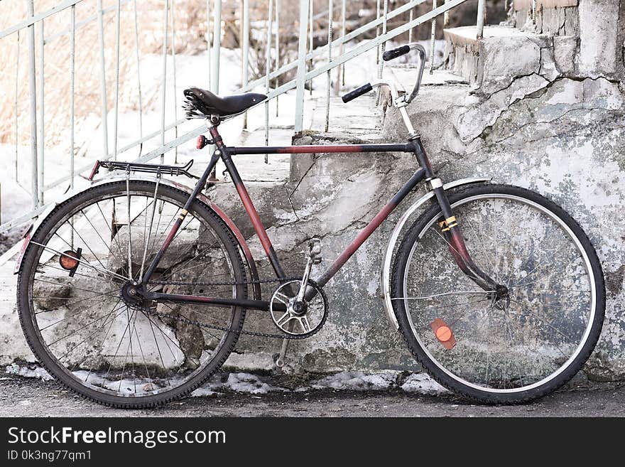 The old bicycle stands near the building