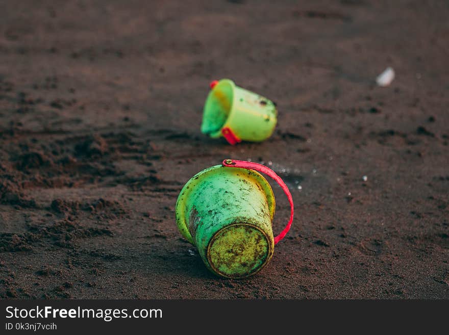 Two Green Pails on Ground