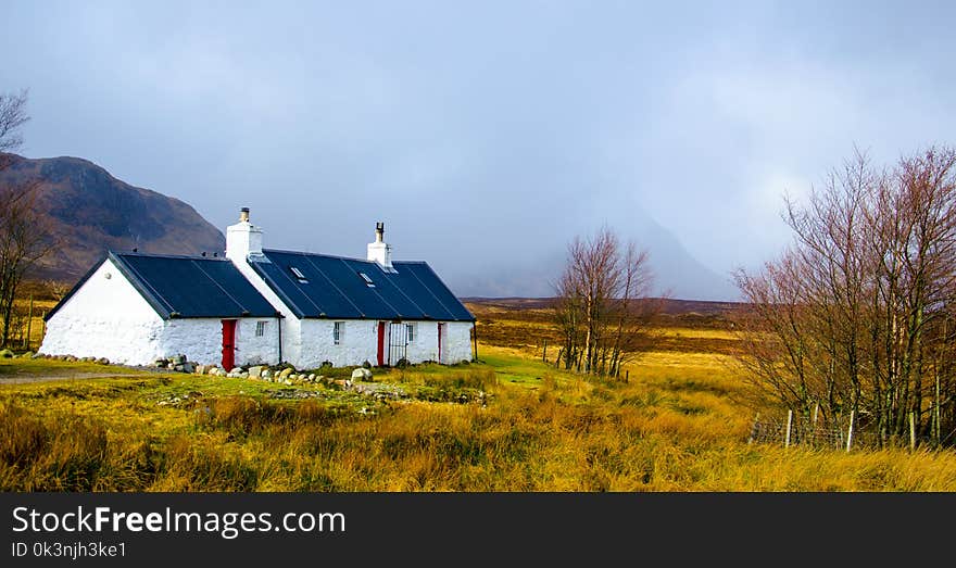 White and Blue House Under Cumulus Nimbus Clouds