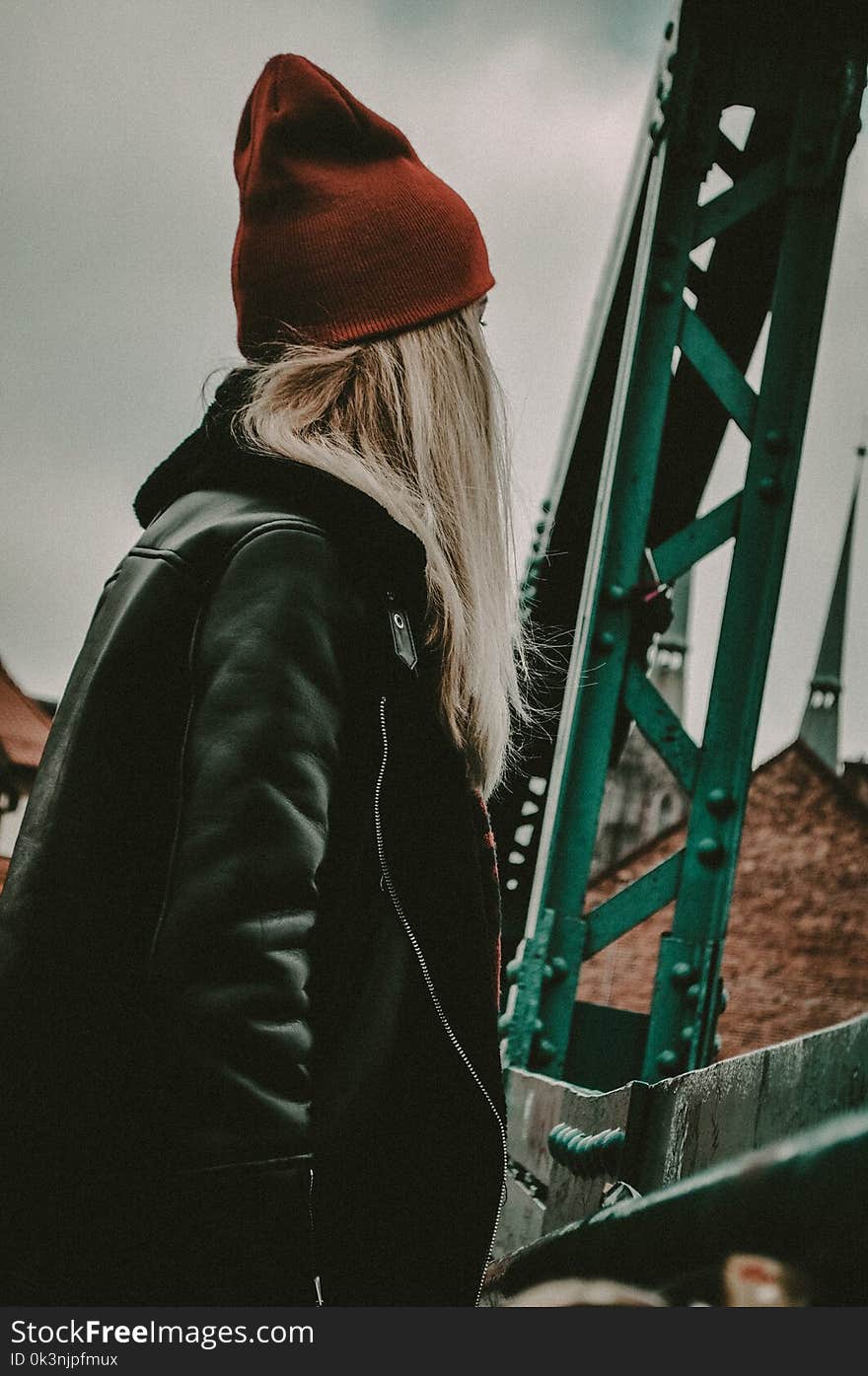 Woman in Black Leather Zip-up Jacket Near Green Metal Stand