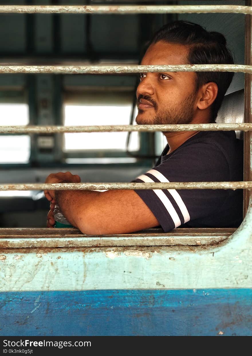 Man Wearing Black and White T-shirt Inside a Vehicle