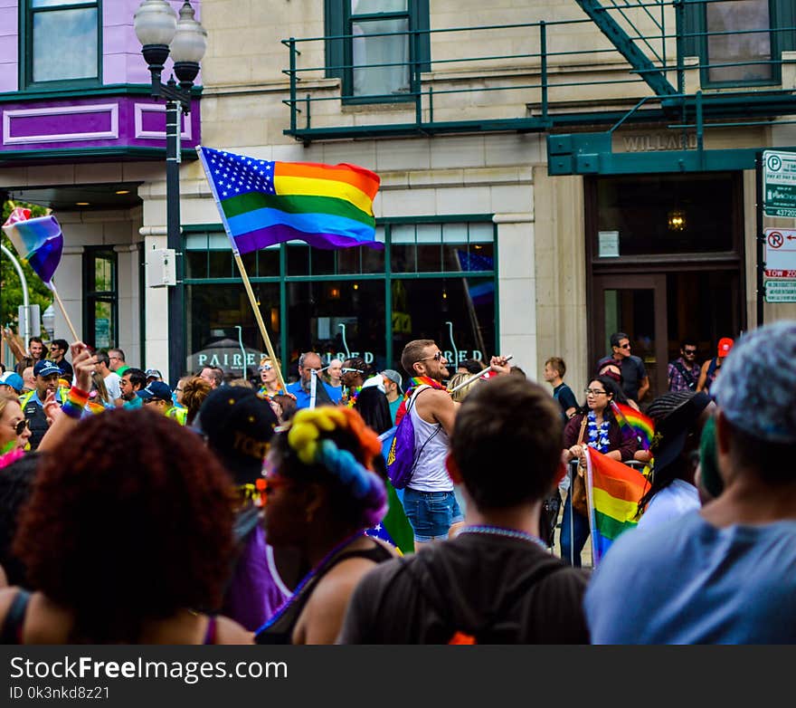 People Gathered Near Building Holding Flag at Daytime