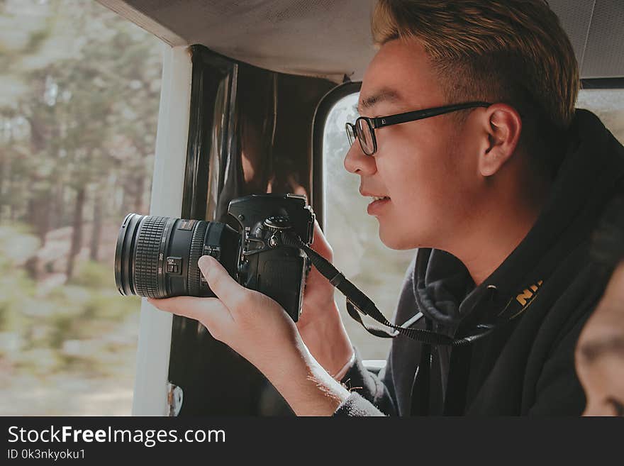 Photo of Man Holding Nikon Dslr Camera