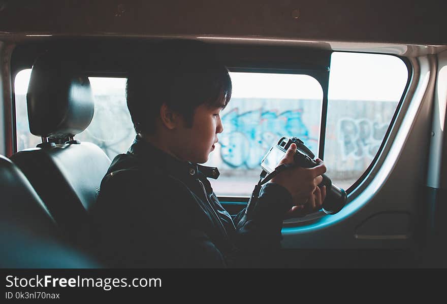 Photo of Man Holding Dslr Camera Looking at Photos