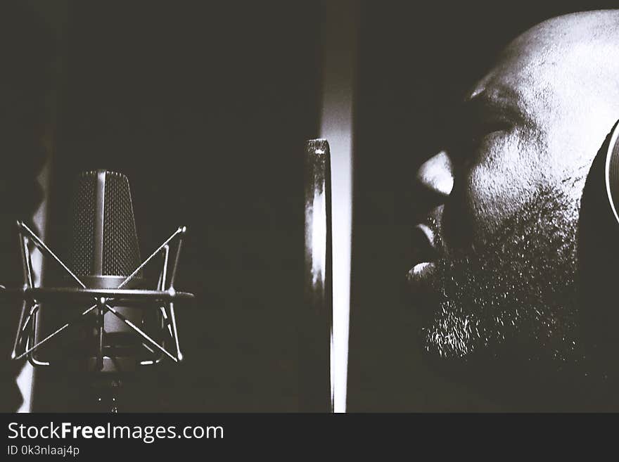 Man Singing Near Pop Filter and Condensing Microphone