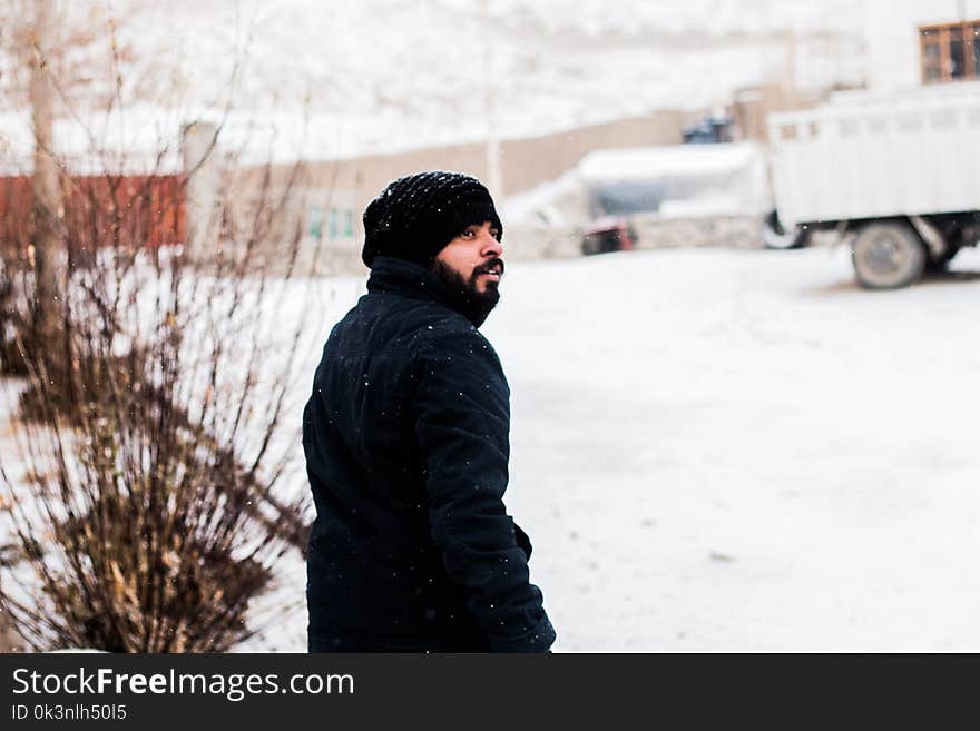 Photo of a Man Wearing Coat During Snow