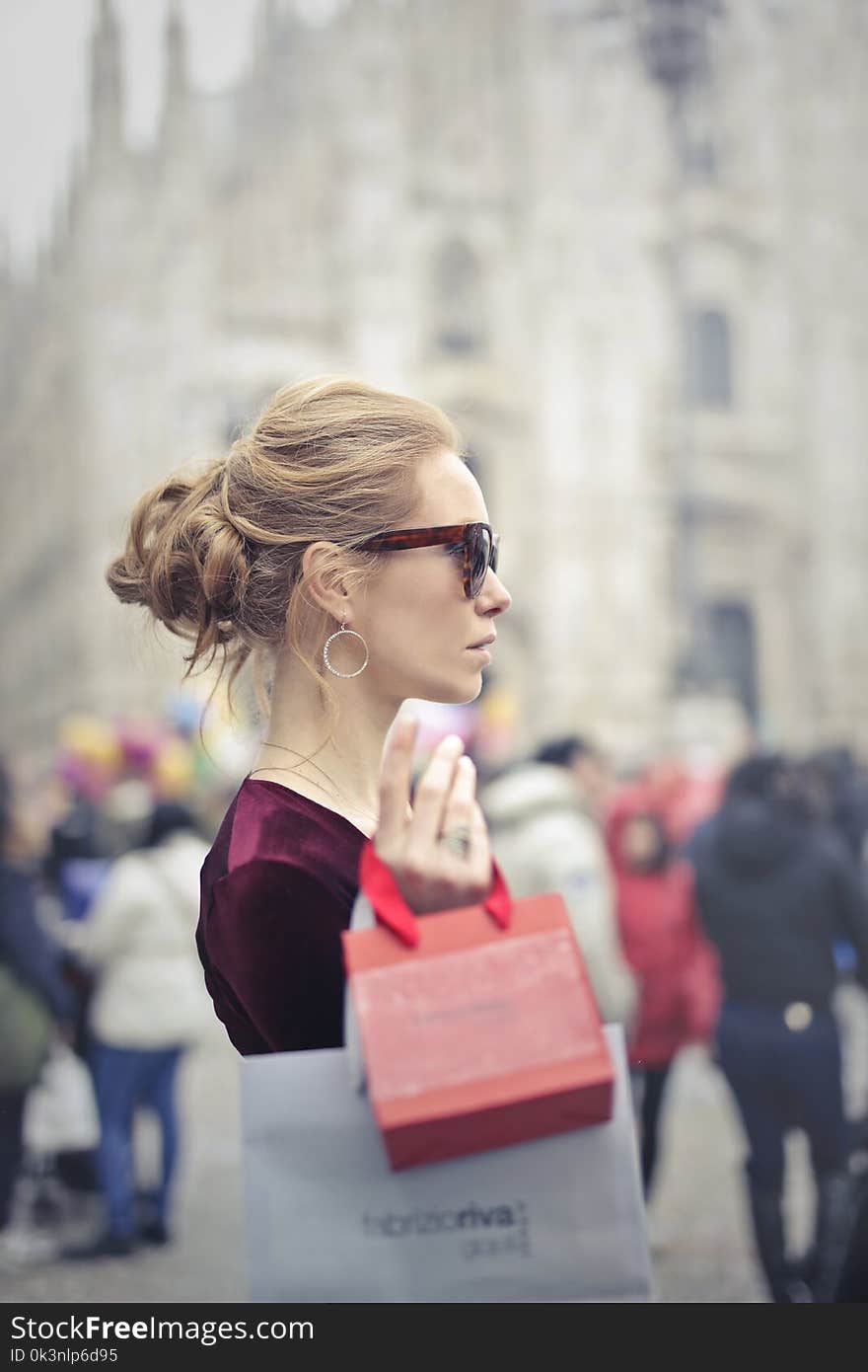 Woman Wearing Red Top Carrying Red Paper Tote Bag