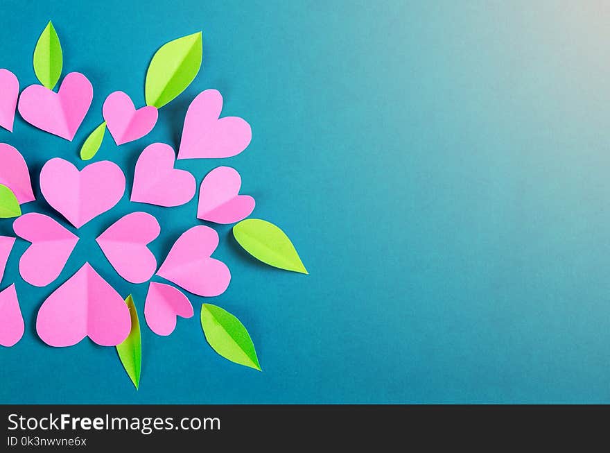 Pink paper cut heart shape and leaf on blue background. Pink paper cut heart shape and leaf on blue background.