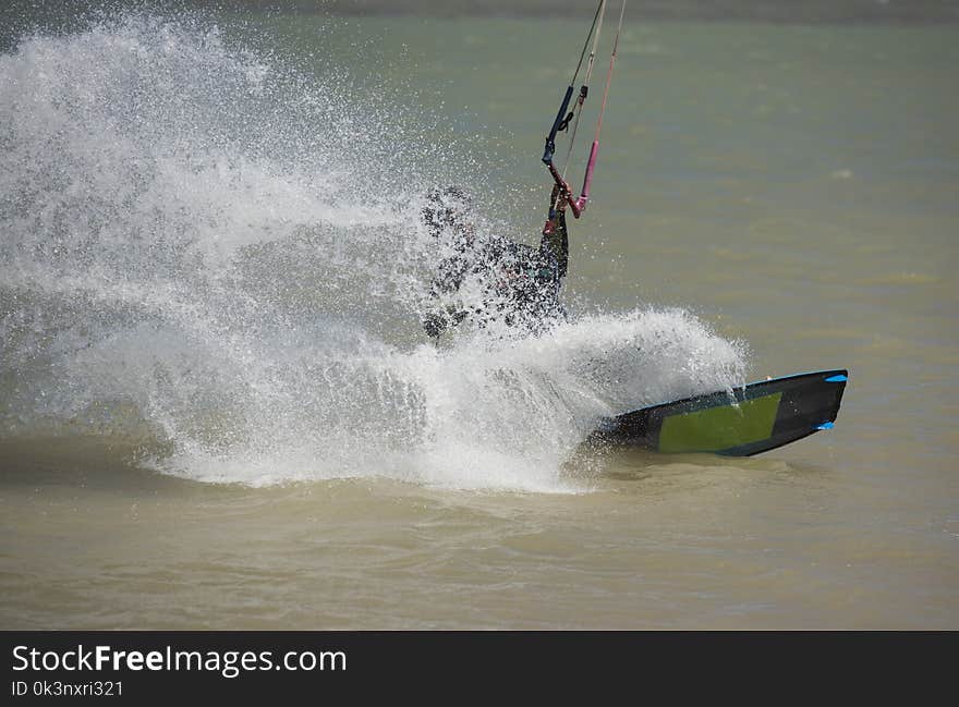 Recreational sport kitesurfer surfing over lagoon in tropcial sea with wake splash. Recreational sport kitesurfer surfing over lagoon in tropcial sea with wake splash