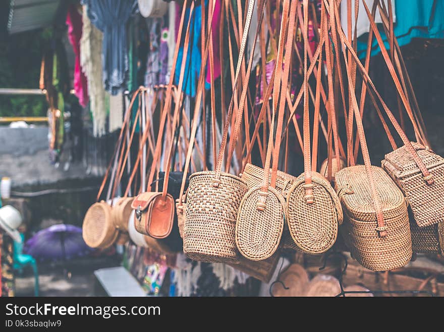 Rattan handbags hanging in the outdoor local asian store. Bali island.