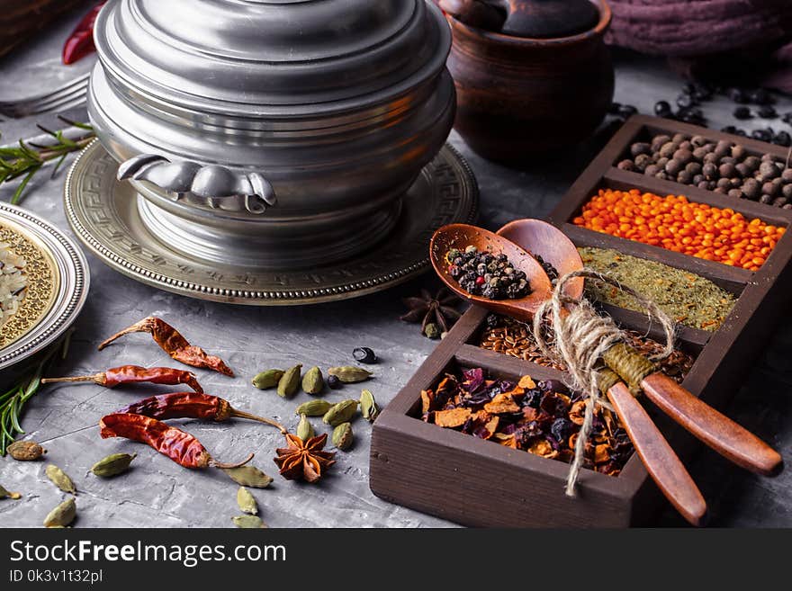 Spices for cooking with kitchen accessories on an old background