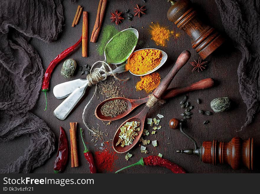 Spices for cooking with kitchen accessories on an old background