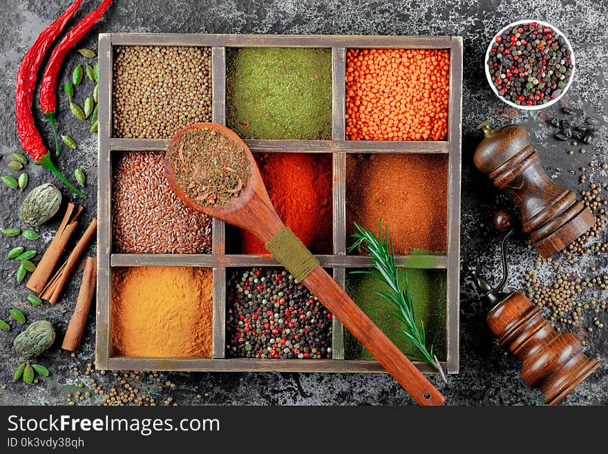 Spices for cooking with kitchen accessories on an old background