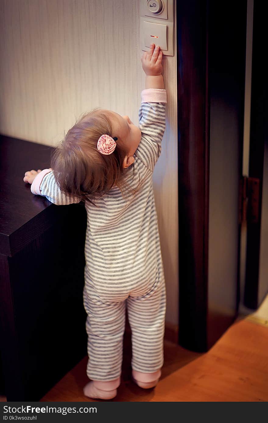 Young girl standing and touching switch