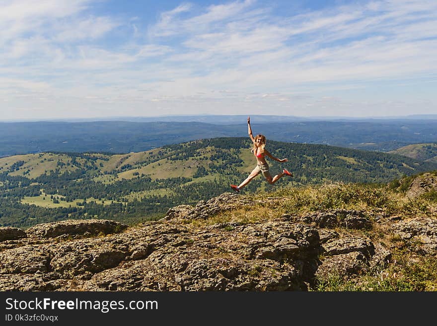 Girl jumping high in the mountains