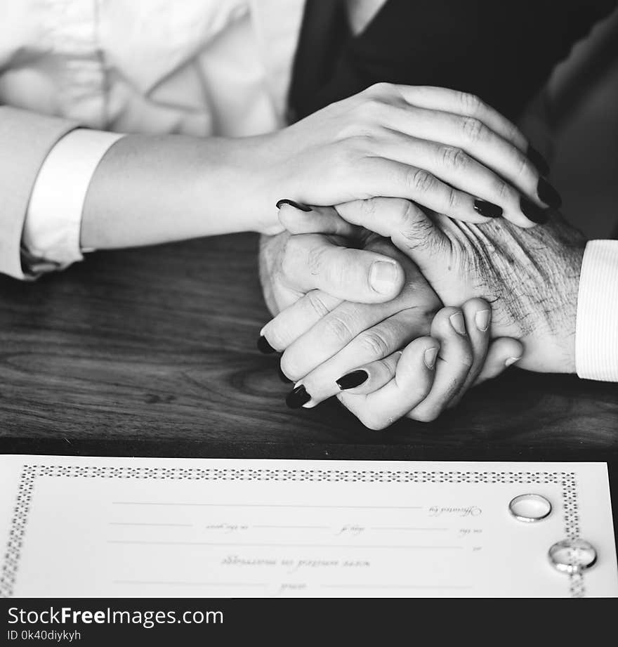 Person Holding Their Hands on Brown Wooden Table