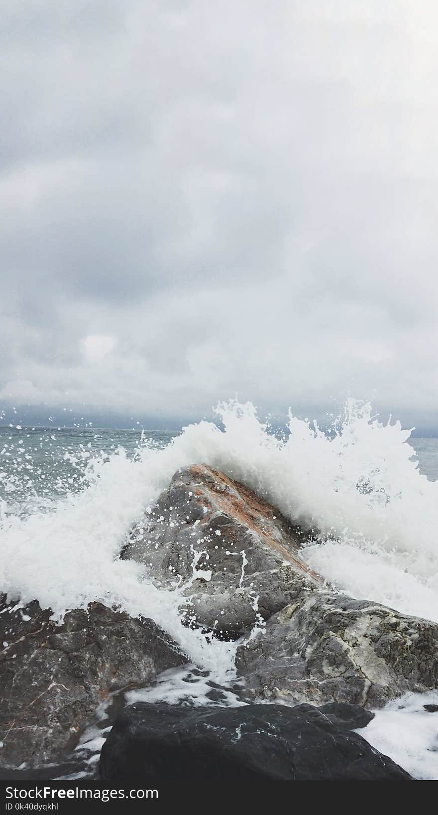 Person Taking Photo of Sea Waves and Gray Concrete Rock