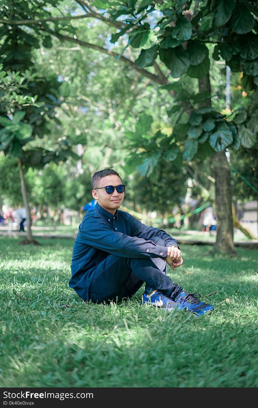 Man Wearing Blue Dress Shirts Seating on Grass