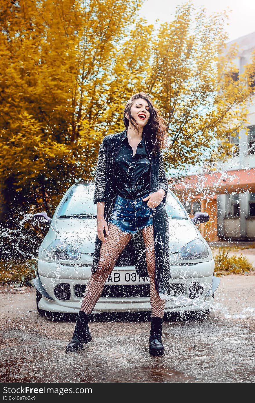 Woman in Black Long-sleeved Top and Blue Denim Shorts Standing in Front of Car