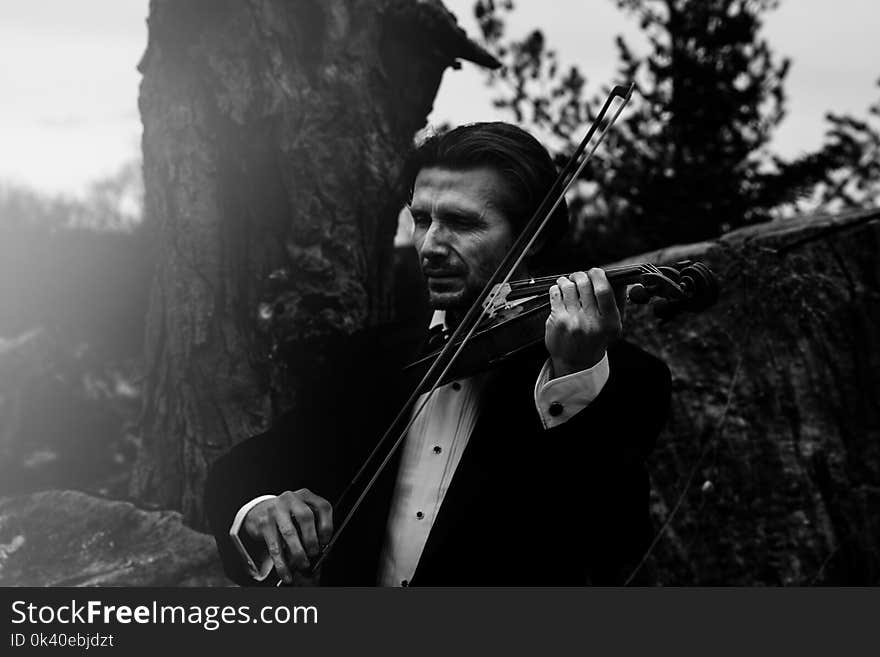 Grayscale Photo of Man Playing Violin