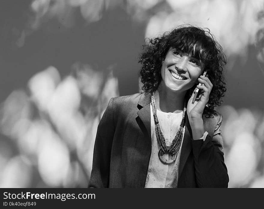 Grayscale Photo of Woman Using Her Phone