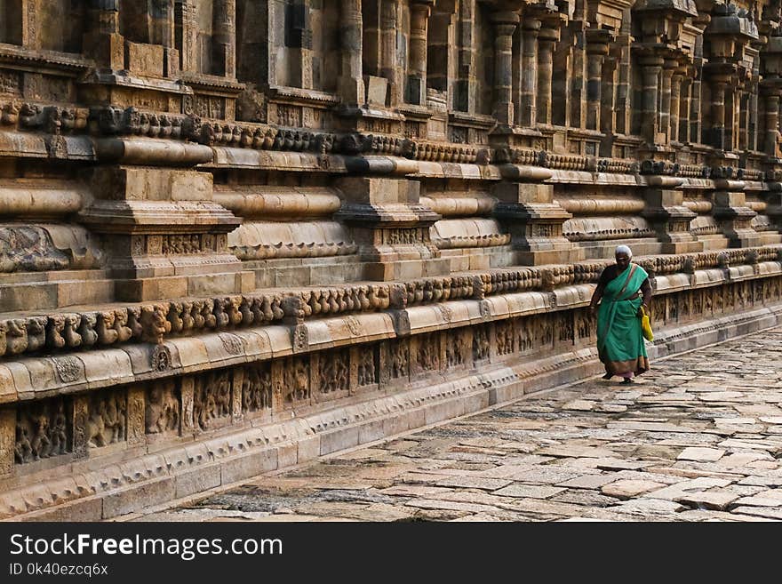 Photo of Woman Wearing Teal Traditional Dress Walking Along Pavement