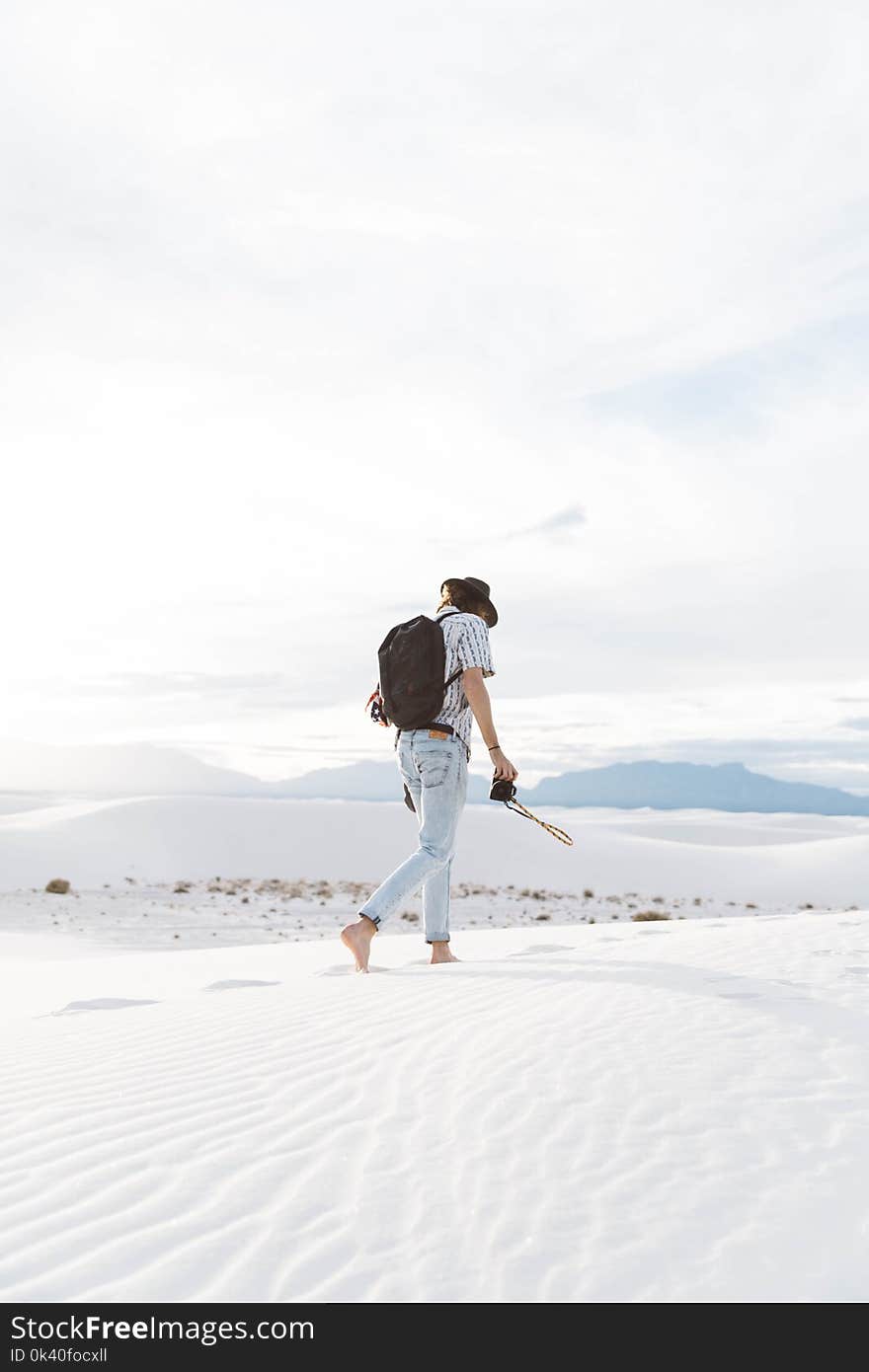 Photo of Person Walking Along Seashore