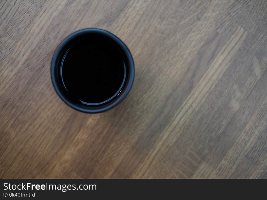 Black Plastic Cup in Top of Brown Wooden Surface