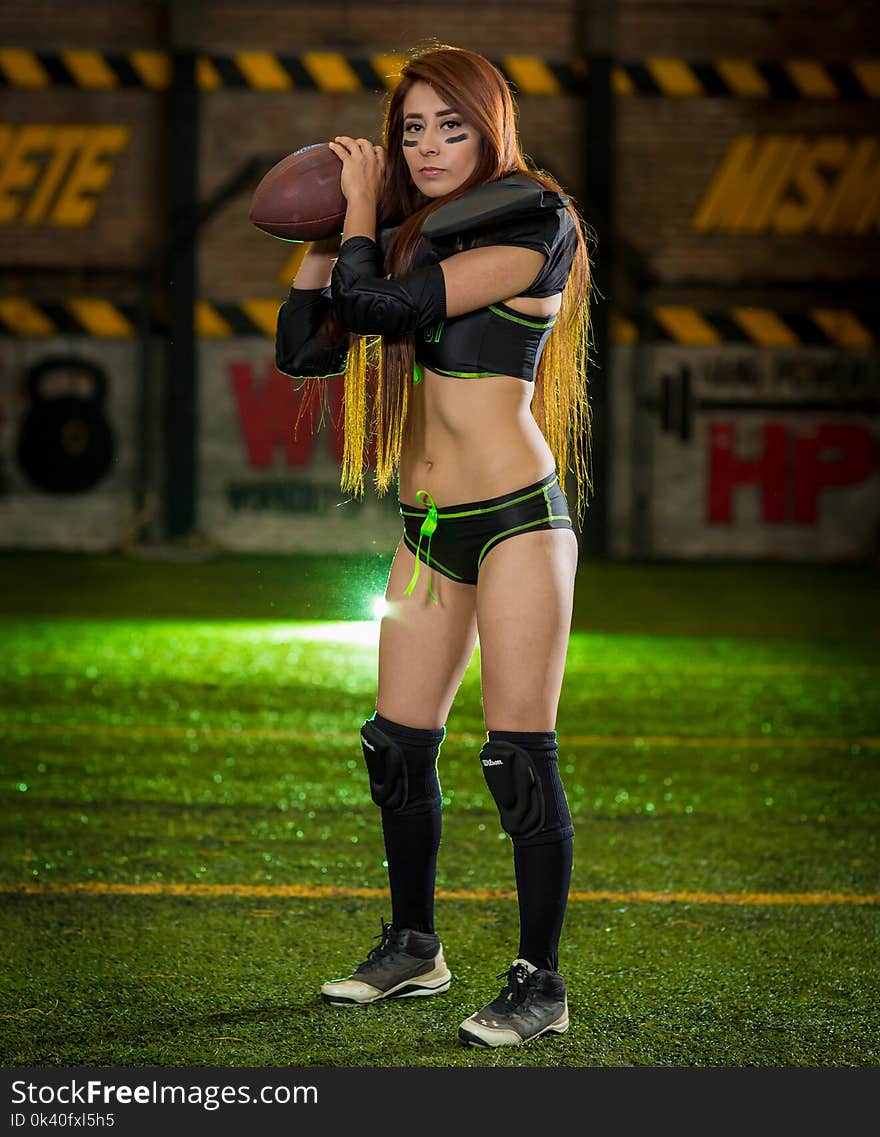 Woman Wearing Black-and-green Sports Bra and Pantie Holding Rugby Ball