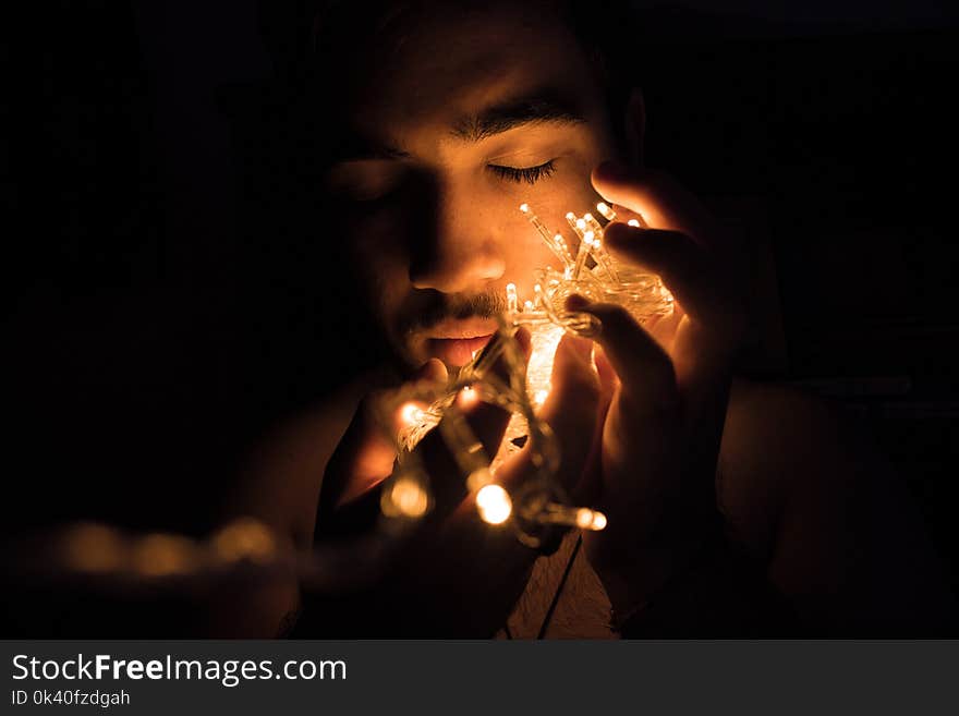 Close-up Photography of Man Holding Christmas Lights