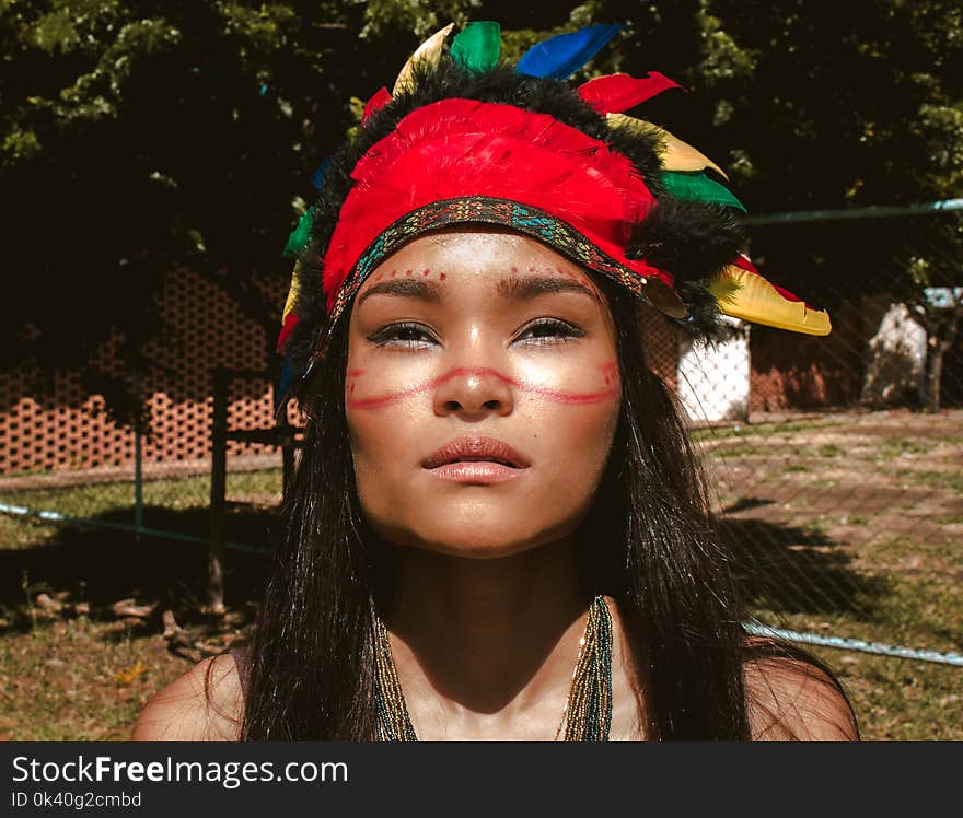 Woman Wearing Red and Black Feather Hat