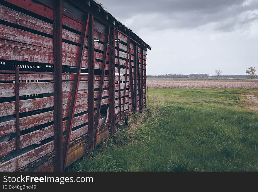 Photo of Red Wooden Shed on Green Grass Field