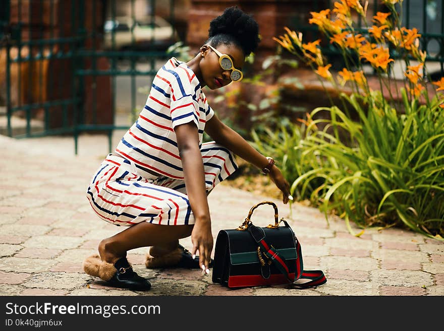 Woman Wearing White Sunglasses and Stripe Shirt Sitting