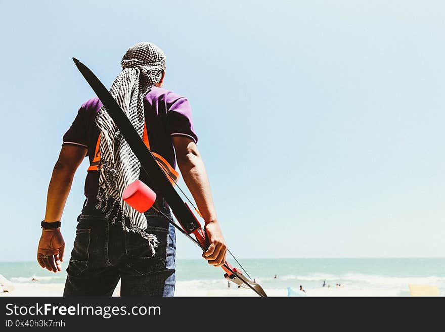 Man Holding Bow in Seashore